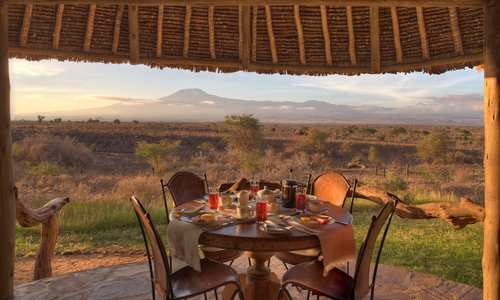 Breakfast table at sunrise on safari with mountain views