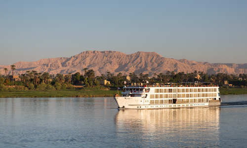 white and luxurious Uniworld SS Sphinx on the River Nile at sunset and calm waters